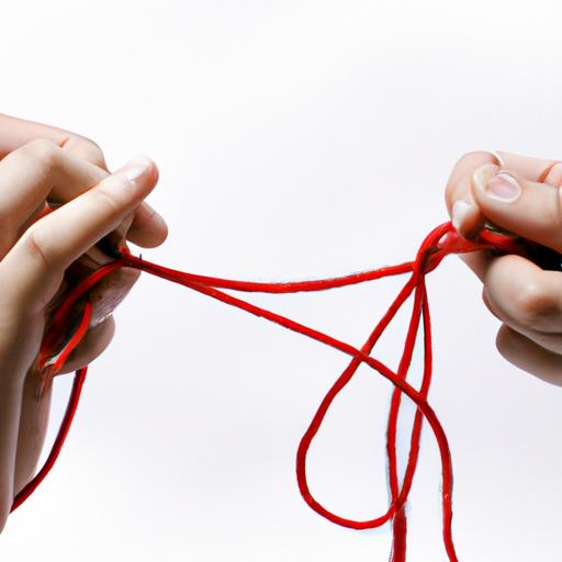 Hình ảnh hai bàn tay cố gắng tháo rối một sợi dây đỏ